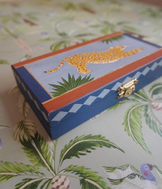 Decorative box with a jaguar design on a patterned surface